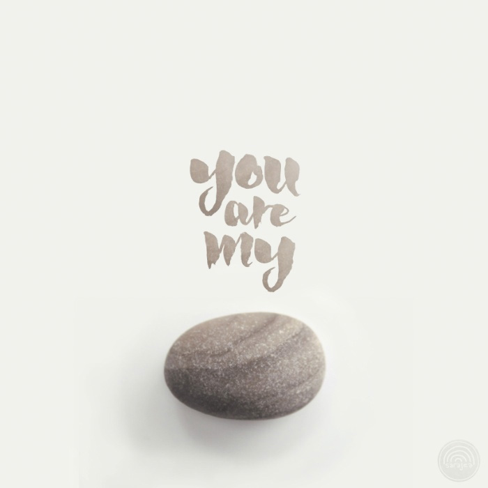 Photograph of a smooth, grey-brown stone. The words "you are my rock" are written above it in matching grey-brown